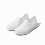 A pair of white slip on loafers for women with white sole for everyday comfort