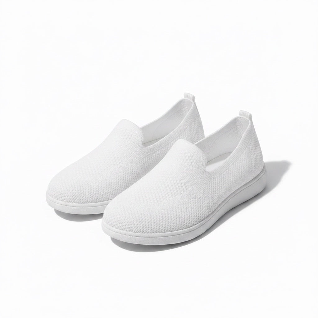 A pair of white slip on loafers for women with white sole for everyday comfort