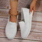 White slip on Loafers shoes shown by female model.
